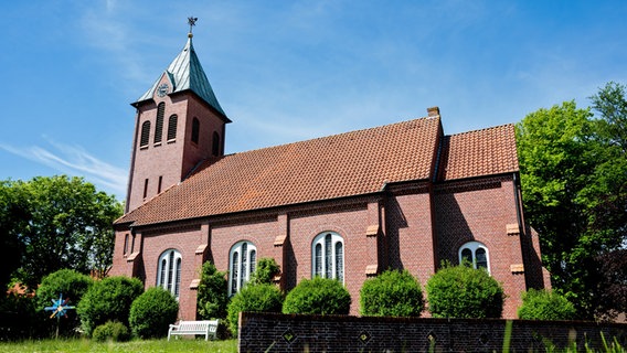 Die Inselkirche Sankt Nikolai steht bei sonnigem Wetter am Dorfplatz im Ortskern der Insel Wangerooge (Niedersachsen). © Hauke-Christian Dittrich Foto: Hauke-Christian Dittrich