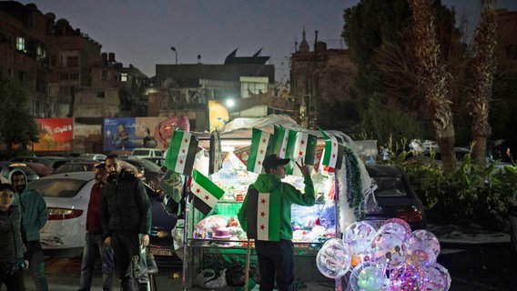 Ein Straßenverkäufer zeigt ein Siegeszeichen im Viertel Bab Touma in der Altstadt von Damaskus (Syrien). © AP/dpa Foto: Leo Correa