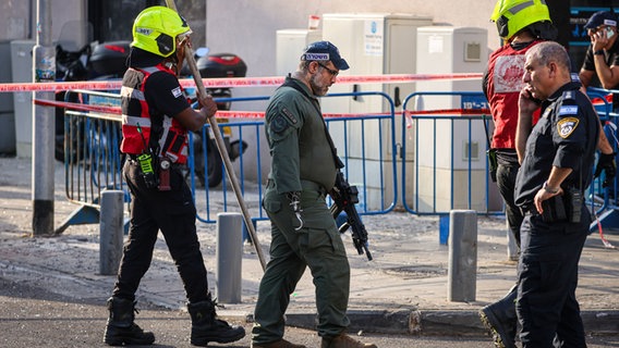 Israelische Polizisten durchsuchen den Ort einer Explosion in Tel Aviv. © dpa Foto: Ilia Yefimovich