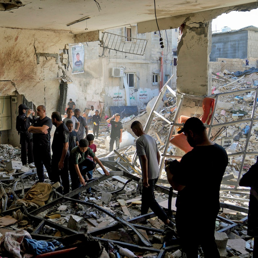 Palästinenser begutachten die Schäden in einem Cafe nach einem israelischen Luftangriff in der Stadt Tulkarem im Westjordanland (Israel). © AP Foto: Nasser Nasser