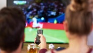 Ein Mann und eine Frau gucken gemeinsam Fußball auf dem Fernseher. © picture alliance 