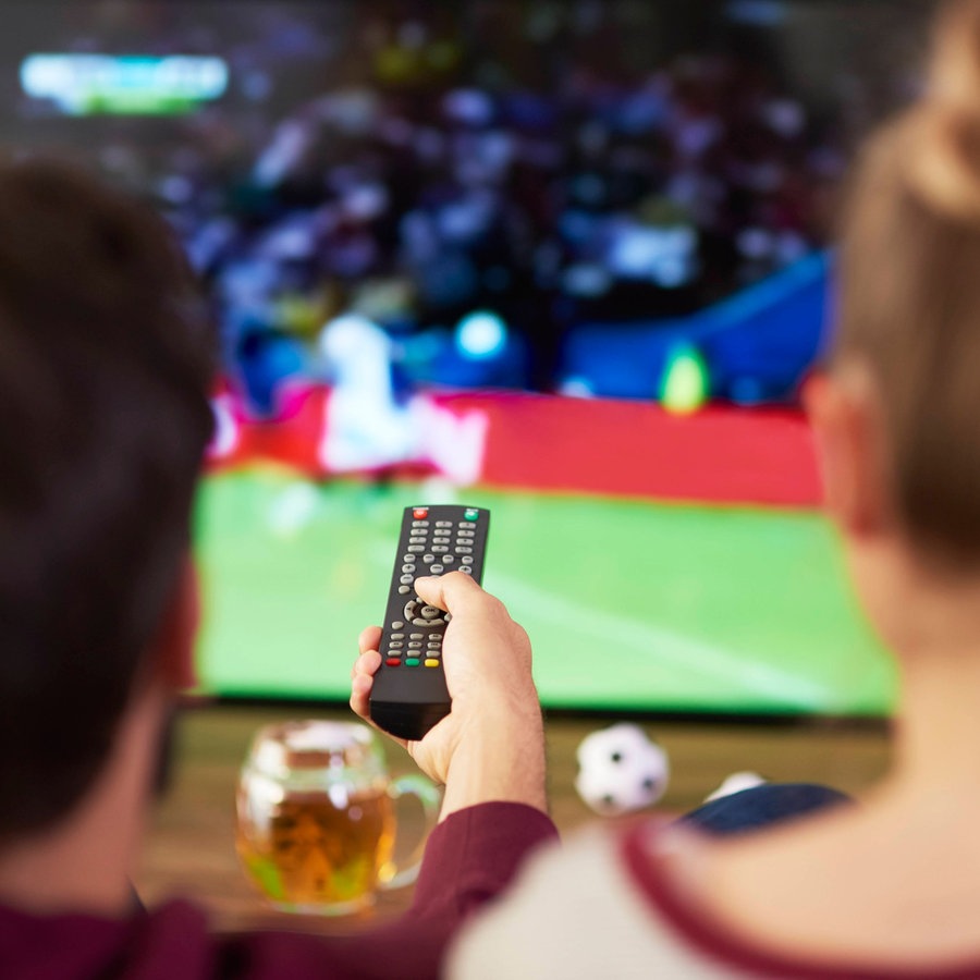Ein Mann und eine Frau gucken gemeinsam Fußball auf dem Fernseher. © picture alliance 