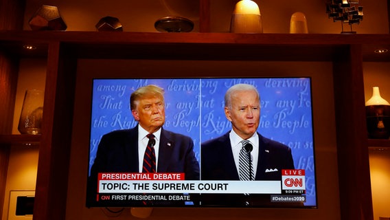 Die US-Präsidentschaftskandidaten Joe Biden und Donald Trump im ersten TV-Duell vor der US-Wahl 2020 wird auf einem Fernseher in einer Schrankwand angesehen. © abaca Foto: Gripas Yuri