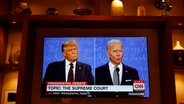 Die US-Präsidentschaftskandidaten Joe Biden und Donald Trump im ersten TV-Duell vor der US-Wahl 2020 wird auf einem Fernseher in einer Schrankwand angesehen. © abaca Foto: Gripas Yuri