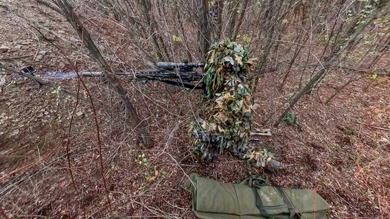 Ein gut getarnter russischer Scharfschütze feuert von einem nicht genannten Ort aus in Richtung der ukrainischen Streitkräfte. © Uncredited/Russian Defense Ministry Press Service via AP/dpa 