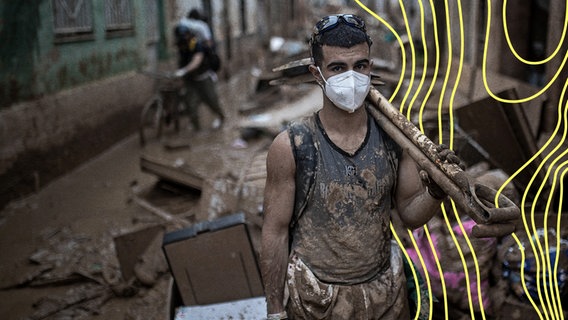 Ein junger Mann mit Atemschutzmaske und Schlammspuren bei Aufräumarbeiten nach einer von einer durch ein Unwetter ausgelösten Flut in Valencia. © picture alliance Foto: Robert Bonet