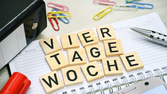 Kalender und Schriftzug Vier-Tage-Woche. © picture alliance Foto: Christian Ohde