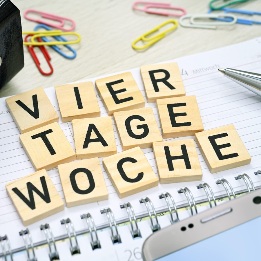 Kalender und Schriftzug Vier-Tage-Woche. © picture alliance Foto: Christian Ohde