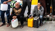 Palästinensische Gebiete, Rafah: Palästinenser warten am dritten Tag der Waffenruhe im Gazastreifen mit Kanistern in der Hand vor einer Tankstelle, um Benzin und Diesel zu tanken. © dpa Foto: Abed Rahim Khatib