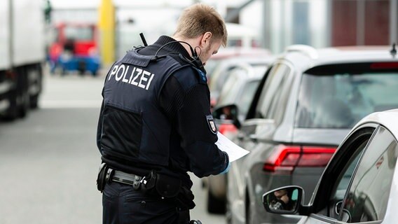 Ein Polizeibeamter kontrolliert einen Autofahrer. © dpa bildfunk Foto: Frank Molter