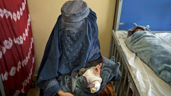 Eine Frau hält ein Baby in der Unterernährungsstation des Hospitals auf dem Arm. © dpa/AP Foto: Felipe Dana