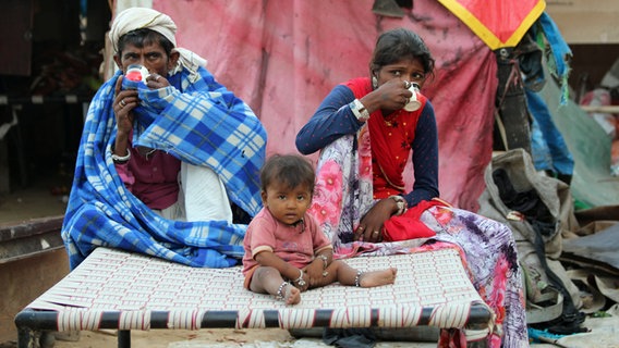 Ärmliche Familie trinkt Tee auf der Straße. © NDR Info 