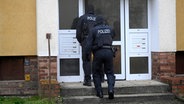 Beamte der Bundespolizei gehen in ein Wohnhaus unweit des Rostocker Ostseestadions. © dpa Foto: Philip Dulian