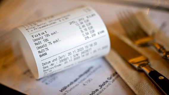 Eine Rechnung mit Umsatzsteuer und Mehrwertsteuer liegt auf der Speisekarte eines Restaurants. © dpa picture alliance Foto: Sina Schuldt