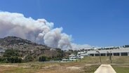 Rauchwolken sind auf der griechischen Insel Rhodos hinter einem Berg zu sehen. © IMAGO / News Images 