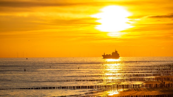 Ein Frachter im Sonnenuntergang vor der niederländischen Küste. © picture alliance Foto: Jochen Tack