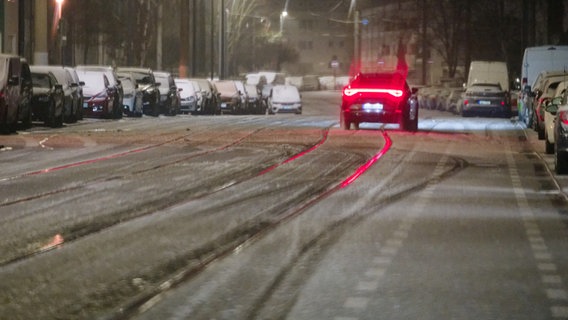 Ein Auto fährt auf einer mit Schneematsch bedeckten Straße. © picture alliance/dpa | Henning Kaiser 