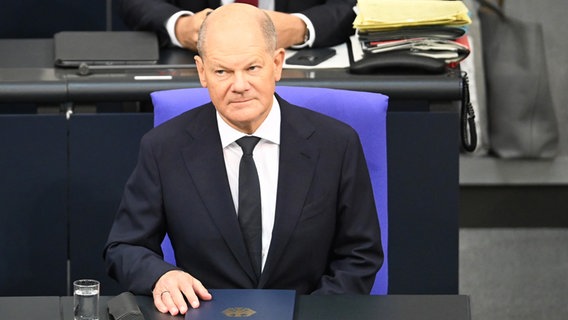 Bundeskanzler Scholz sitzt vor seiner Regierungserklärung an seinem Platz im Bundestag. © dpa Foto: Anna Ross