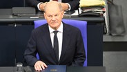 Bundeskanzler Scholz sitzt vor seiner Regierungserklärung an seinem Platz im Bundestag. © dpa Foto: Anna Ross