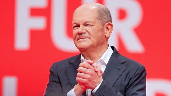 Bundeskanzler Olaf Scholz steht nach seiner Rede beim außerordentlichen SPD-Bundesparteitag auf der Bühne. © dpa-Bildfunk Foto: Michael Kappeler