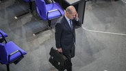 Bundeskanzler Olaf Scholz (SPD) geht im Bundestag nach der Generaldebatte zur "Situation in Deutschland" aus dem Plenarsaal. © picture alliance/dpa | Michael Kappeler 