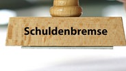 "Schuldenbremse" steht auf einem Stempel. © Imago Foto: McPhoto