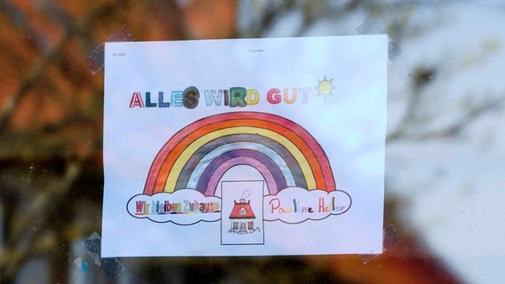 Ein Fensterbild an einer Grundschule in Hannover mit einem Regenbogen und der Aufschrift: "Alles wird gut" © imago images / Future Image 