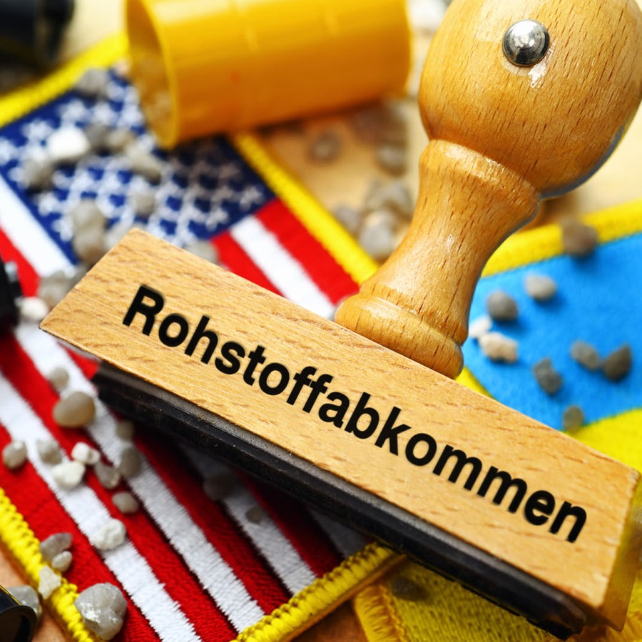 Stempel mit Aufschrift Rohstoffabkommen auf den Fahnen der USA und Ukraine mit Fässern und Steinen, Symbolfoto Rohstoff-Deal zwischen den USA und der Ukraine, Fotomontage © picture alliance / CHROMORANGE | Christian Ohde Foto: Christian Ohde