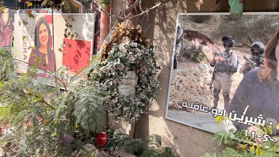 Fotos der getöteten Journalistin und ein Kranz an der Straße, an der sie ermordet wurde. © ARD Foto: Bettina Meier