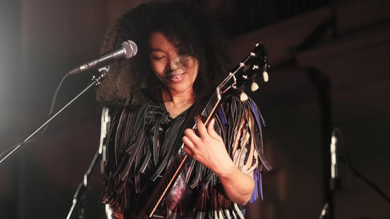 Die amerikanische Gitarristen und Sängerin Judith Hill steht vor einem Mikrofon und spielt Gitarre © picture alliance / Sipa USA | LiveMedia Foto: Michele Nucci