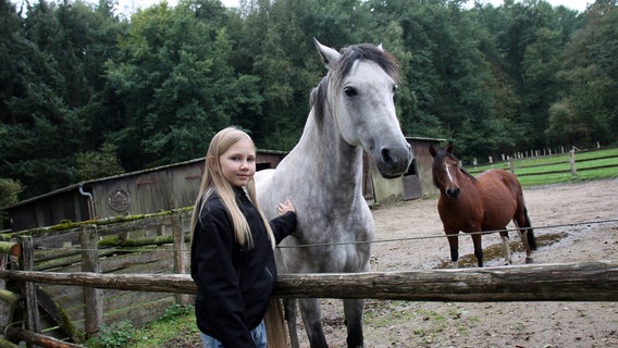 Ein Kind streichelt ein Pferd und blickt in die Kamera. © NDR Mikado Foto: Aniko Schuster