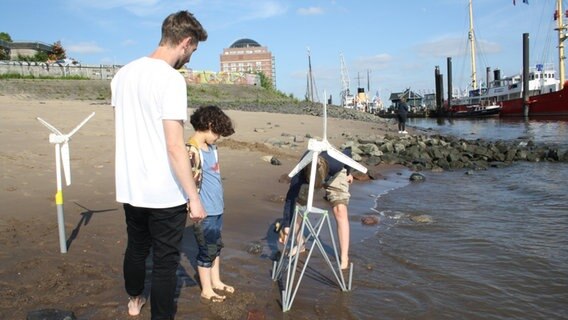 Ein Mann und zwei junge Kinder bauen etwas am Strand. © NDR Mikado/Sahin 