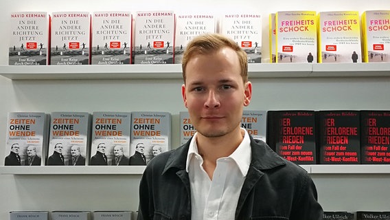 Der Buchautor Christian Schweppe steht in einer Buchhandlung. © Christian Schweppe 