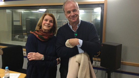 Senta Berger, die links von Hubertus Meyer-Burckhardt steht, befinden sich im Hörfunkstudio und lächeln in die Kamera. © NDR Info Foto: Doris Schiederig