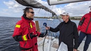 Ein lächelnder Reporter interviewed einen Skipper auf einer Jacht in der Ägäis © NDR Foto: Carsten Vick