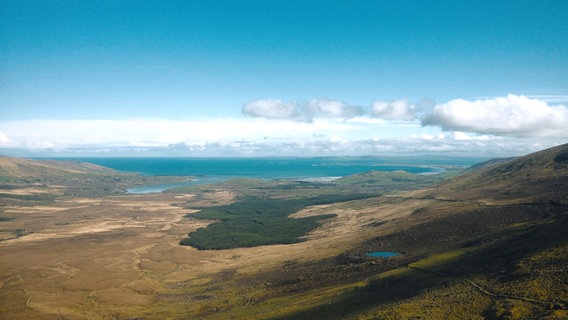 Blick aus der Vogelflugperspektive auf eine Landschafte voller schroffer Felsen, blauem Meer, und weißen Wolken (in Irland) © NDR Foto: Matthias Schuch