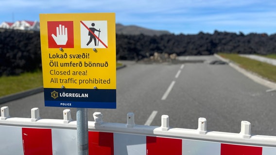 Ein Schild vor einer versperrten Landstraße voller Lava in Island © NDR Foto: Max-Marian Unger