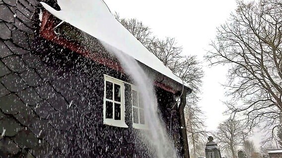 Schnee stürzt von einem Dach in einem Haus mit Schieferdach in Goldauter-Heidersbach © NDR Foto: Jörg Wunram