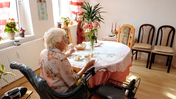 Seniorin sitzt an ihrem Esstisch bei Kaffee und Kuchen © picture-alliance / Sven Simon Foto: FrankHoermann/SVEN SIMON