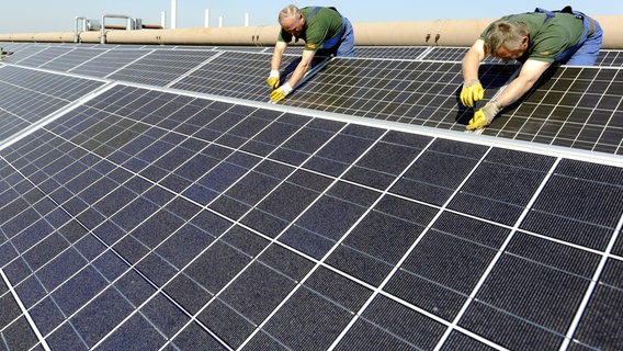 Mitarbeiter eines Unternehmens für Umwelttechnik arbeiten an Solaranlagen © picture-alliance/ dpa | Holger Hollemann Foto: Holger Hollemann