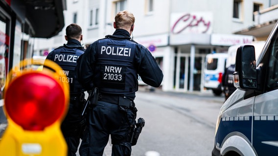 Zwei Polizisten stehen am frühen Morgen an einer Absperrung in der Innenstadt von Solingen (Nordrhein-Westfalen). © picture alliance/dpa Foto: Christoph Reichwein