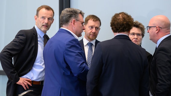 Jörg Scheibe, Co-Vorsitzender des BSW in Sachsen, Christian Hartmann (CDU), Fraktionsvorsitzender im Sächsischen Landtag, Michael Kretschmer (CDU), Ministerpräsident von Sachsen, Medienwissenschaftler Marcel Machill (BSW), Sabine Zimmermann, Co-Vorsitzende des BSW Sachsen, und Henning Homann, Co-Vorsitzender der SPD in Sachsen, stehen vor Beginn der Sondierungsgespräche im Landtag in einem Besprechungsraum. © dpa-Bildfunk Foto: Robert Michael/dpa