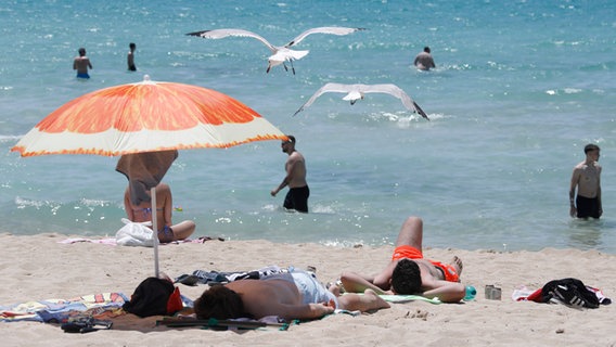 Menschen sonnen sich am Strand von Arenal. © dpa Bildfunk Foto: Clara Margais