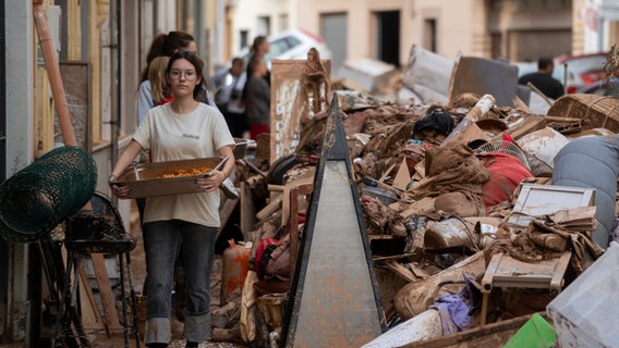 Eine Frau hilft bei den Aufräumarbeiten in Aldaia nach den verheerenden Überschwemmungen im Süden und Osten Spaniens. © EUROPA PRESS/dpa Foto: Jorge Gil