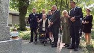 31.07.2024, Polen, Warschau: Wanda Traczyk-Stawska, Teilnehmerin des Warschauer Aufstands 1944, zeigt Bundespräsident Frank-Walter Steinmeier einen Gedenkstein auf dem Friedhof für die toten Aufständischen. Als Zeichen der Erinnerung an deutsche Verbrechen im Zweiten Weltkrieg nahm der Bundespräsident am Gedenken an den Warschauer Aufstand vor 80 Jahren teil. © dpa Foto: Friedemann Kohler