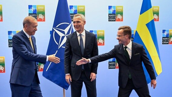 Recep Tayyip Erdogan (l.), Präsident der Türkei, und Ulf Kristersson (r.), Ministerpräsident von Schweden, reichen sich vor ihrem Treffen mit Jens Stoltenberg (M.), Generalsekretär der NATO, im Vorfeld des Nato-Gipfels in Litauen die Hände. © Henrik Montgomery/TT News Agency/AP 