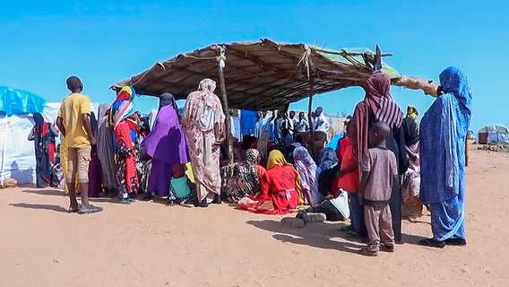 Sudanesische Flüchtlinge versammeln sich vor einem Feldlazarett. © Uncredited/AP/dpa 