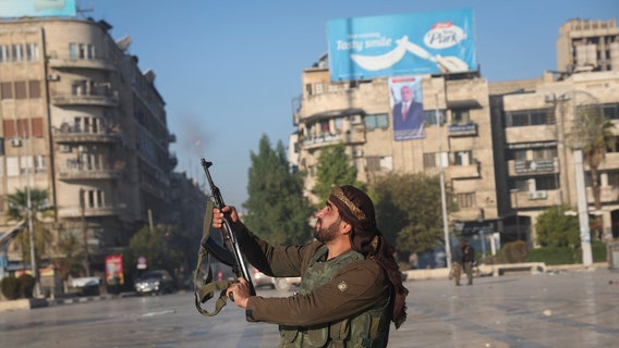 Ein syrischer Oppositionskämpfer schießt in die Luft in der Innenstadt von Aleppo © AP/dpa Foto: Ghaith Alsayed