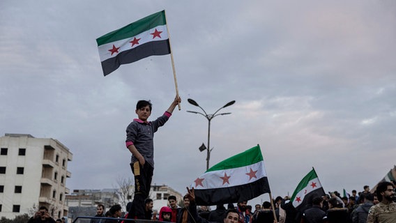 Ein Junge schwenkt im syrischen Manbij eien Flagge der Syrischen Freien Armee © DIA Photo/dpa Foto: Ugur Yildirim