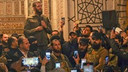 Abu Mohammed al-Dschulani, Anführer der Aufständischen, spricht in der Umayyaden-Moschee in Damaskus in Syrien zu den Rebellen. © dpa-Bildfunk/AP Foto: Omar Albam